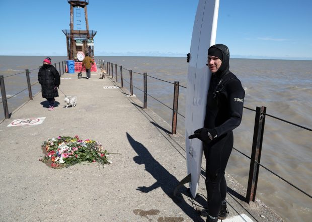 Ted Brady takes a break from surfing in Lake Michigan at Tobey Prinz Beach, near where Sheridan Gorman was fatally, in Chicago on March 23, 2026. Brady said he was in the lake recently when high winds blew flowers from a memorial into the water. He said he retrieved as many as he could and put them back on the pier. (Terrence Antonio James/Chicago Tribune)