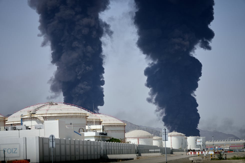 Plumes of smoke rise after debris from an intercepted Iranian drone struck an oil facility,...