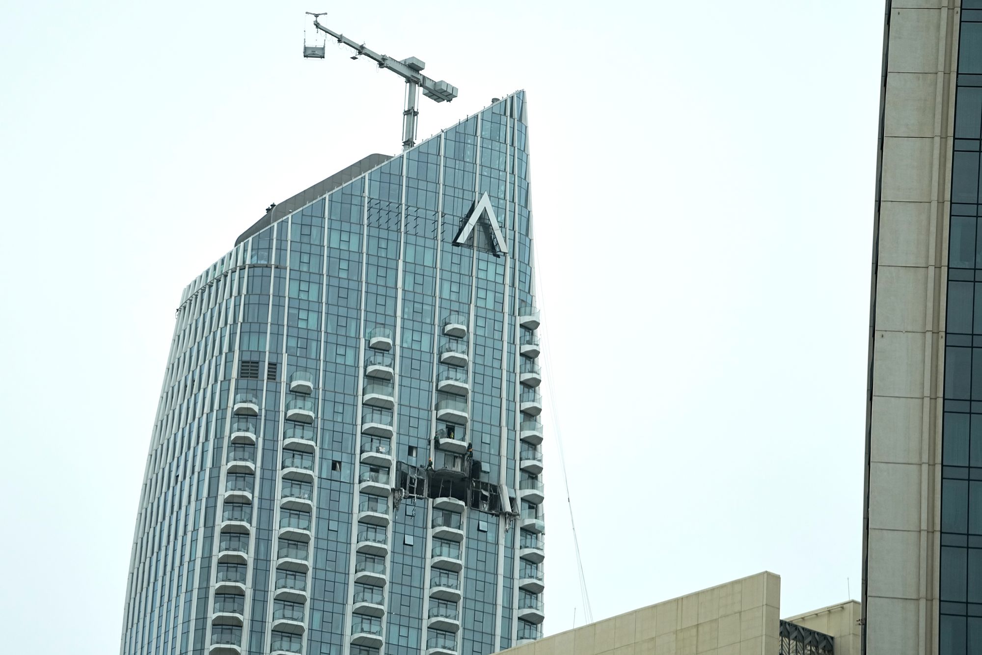 Workers inspect damage to the Address Creek Harbour hotel