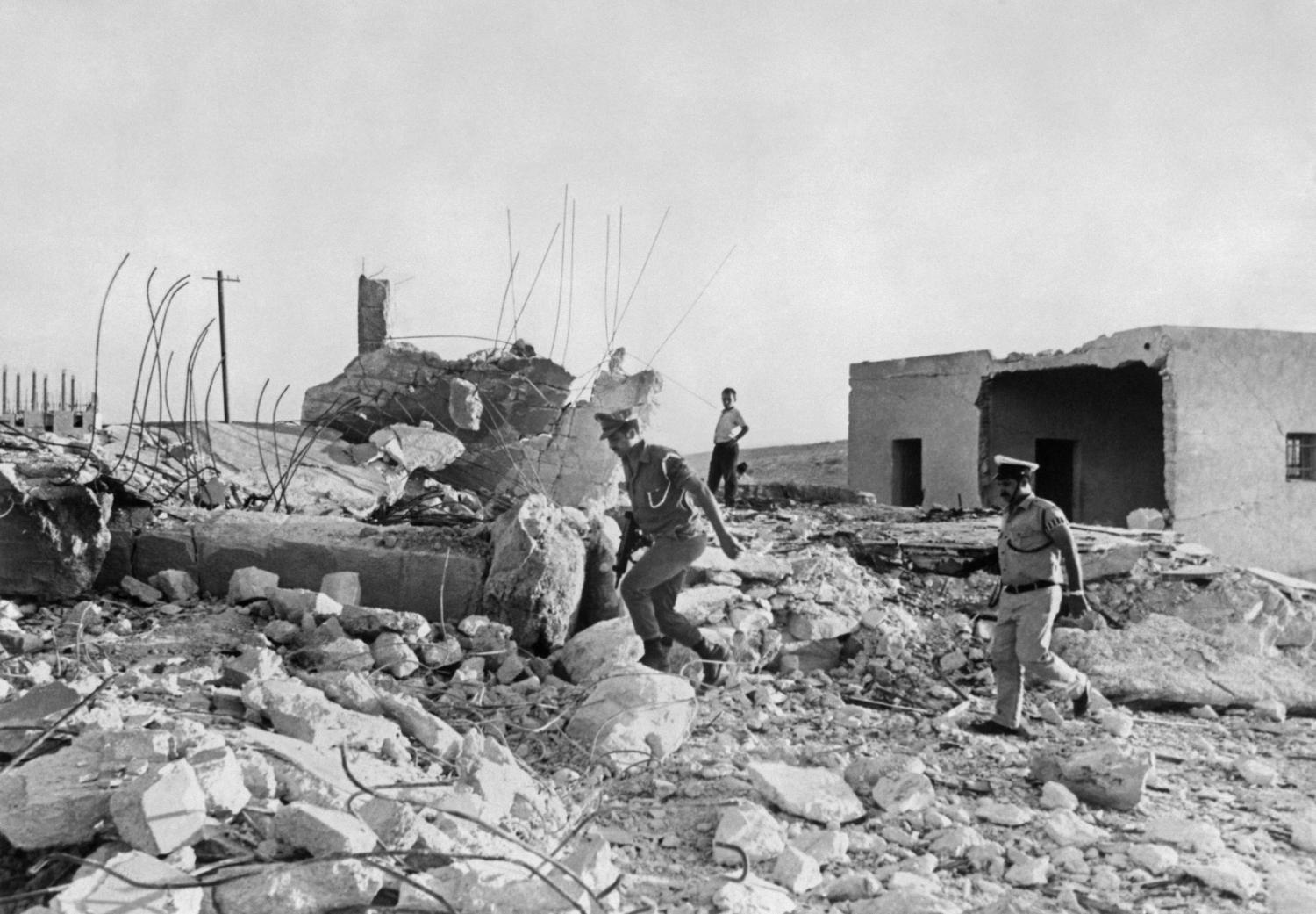 Israeli soldiers inspect the rubble of four dynamited houses belonging to Arabs in the village of Abu Dis, near Jerusalem in the West Bank on August 30, 1967, following the Six-Day War.