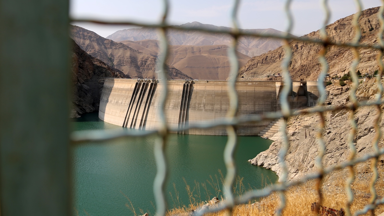 Amir Kabir Dam, one of the five main reservoirs supplying water to Tehran, seen through a chain-link fence