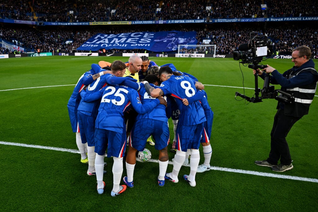Chelsea players enter a huddle surrounding Referee Paul Tierney