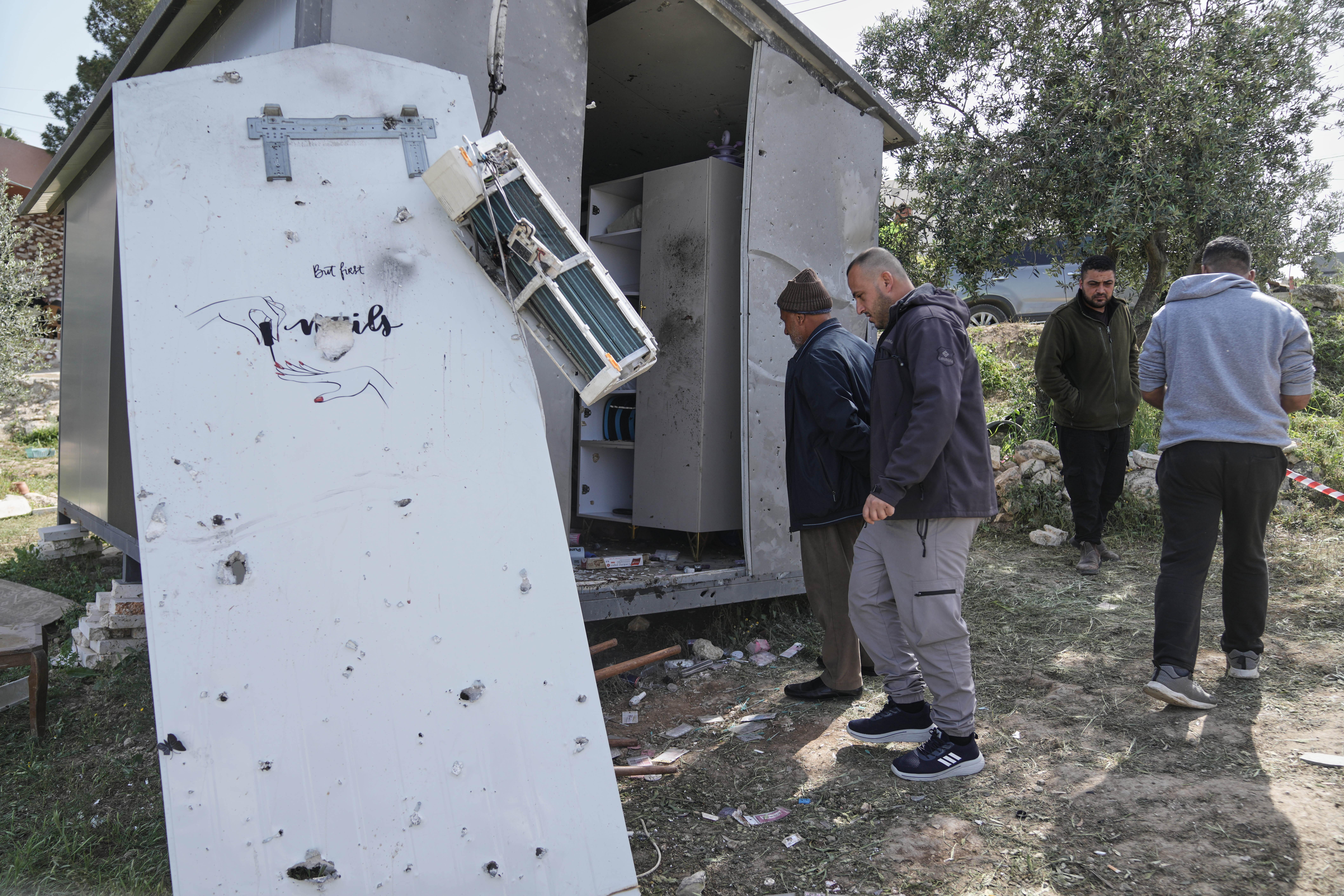 Palestinians inspect the damage at a beauty salon after a deadly Iranian strike in the West Bank.