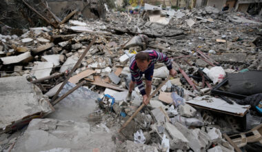 A man removes rubbles as he looks for missed stuff from his destroyed house that was hit in an Isra...
