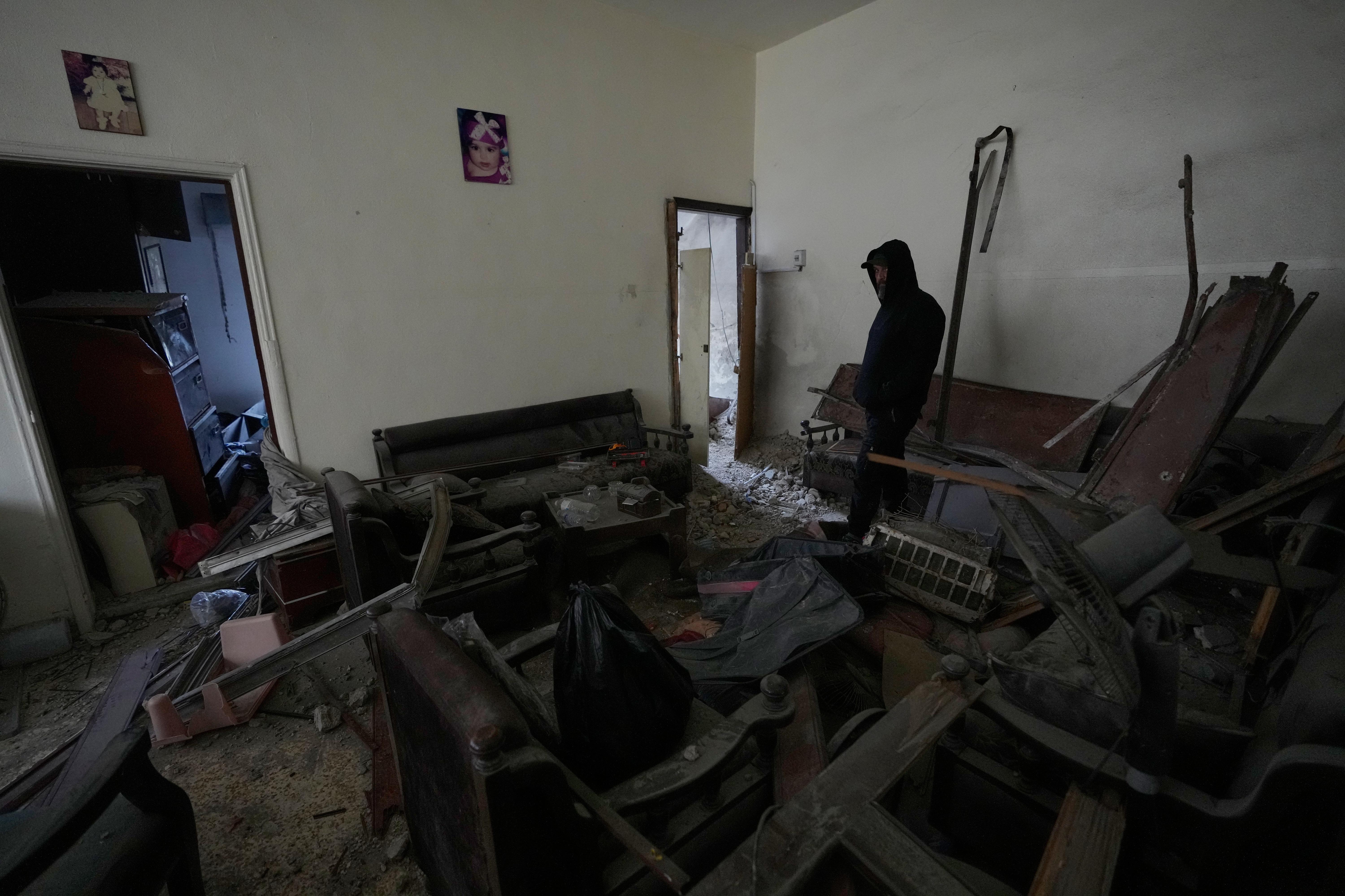 A man checks his damaged apartment at the site of...