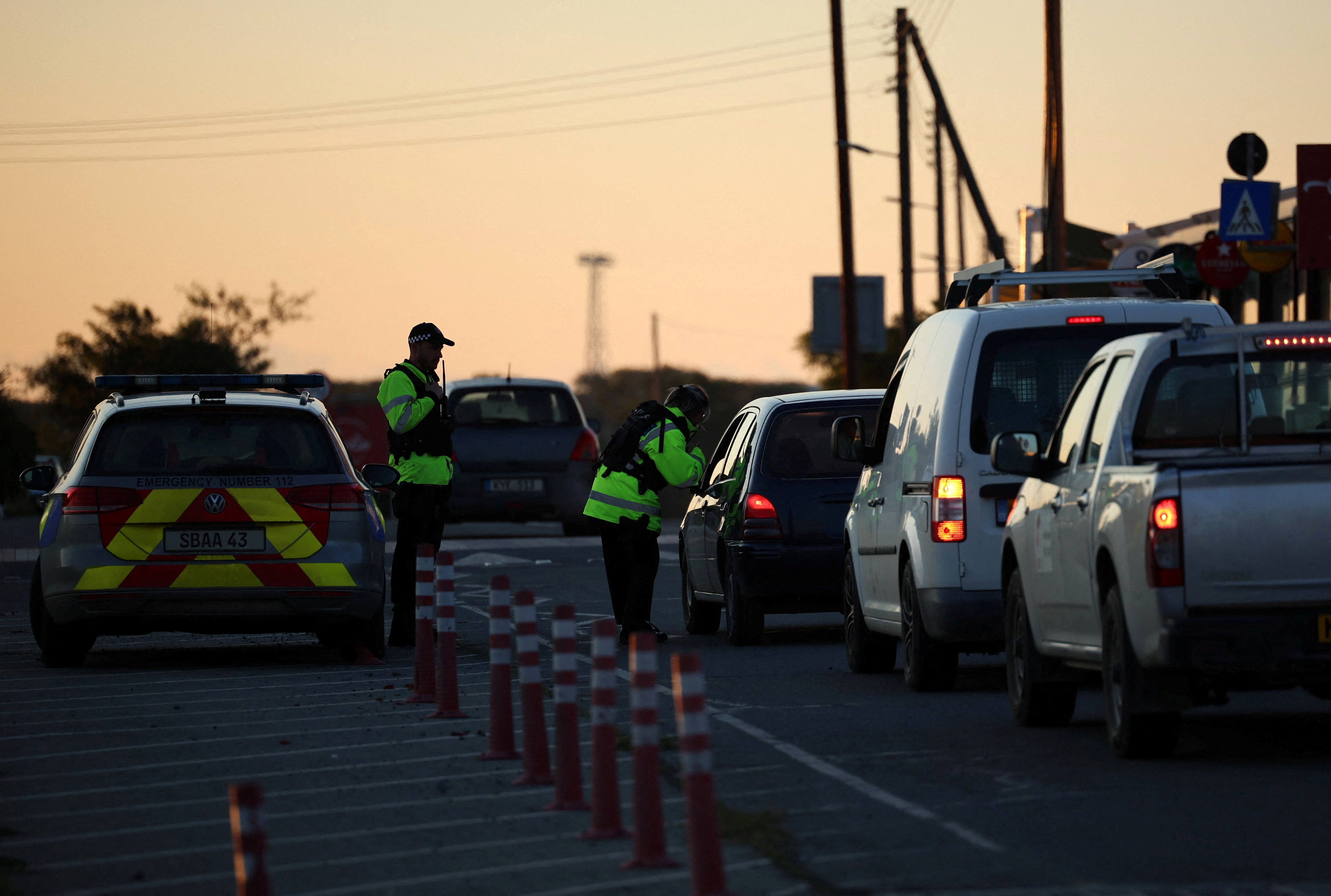 Police check vehicles on the road leading to RAF Akrotiri, a British sovereign base in Cyprus, which was hit by an unmanned drone overnight, causing limited damage.