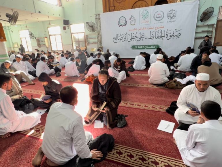 Crowd of keepers sitting in the mosque hall reciting the Qur'an by heart