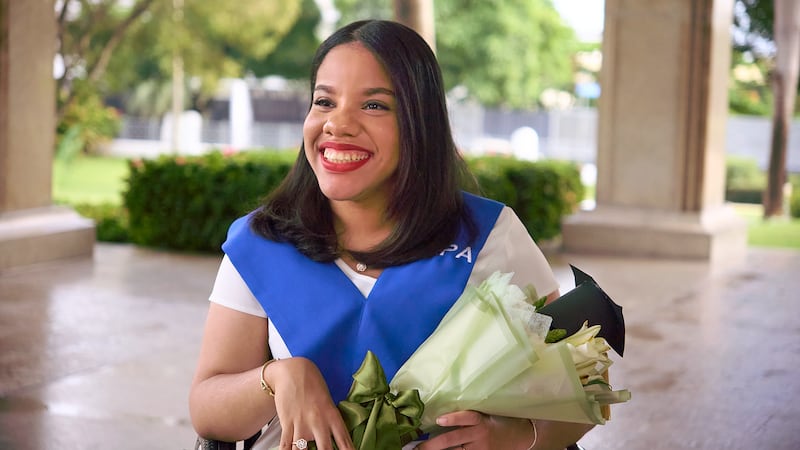 Sidney Peralta poses for a photo after receiving a degree in industrial psychology from the Open University for Adults.