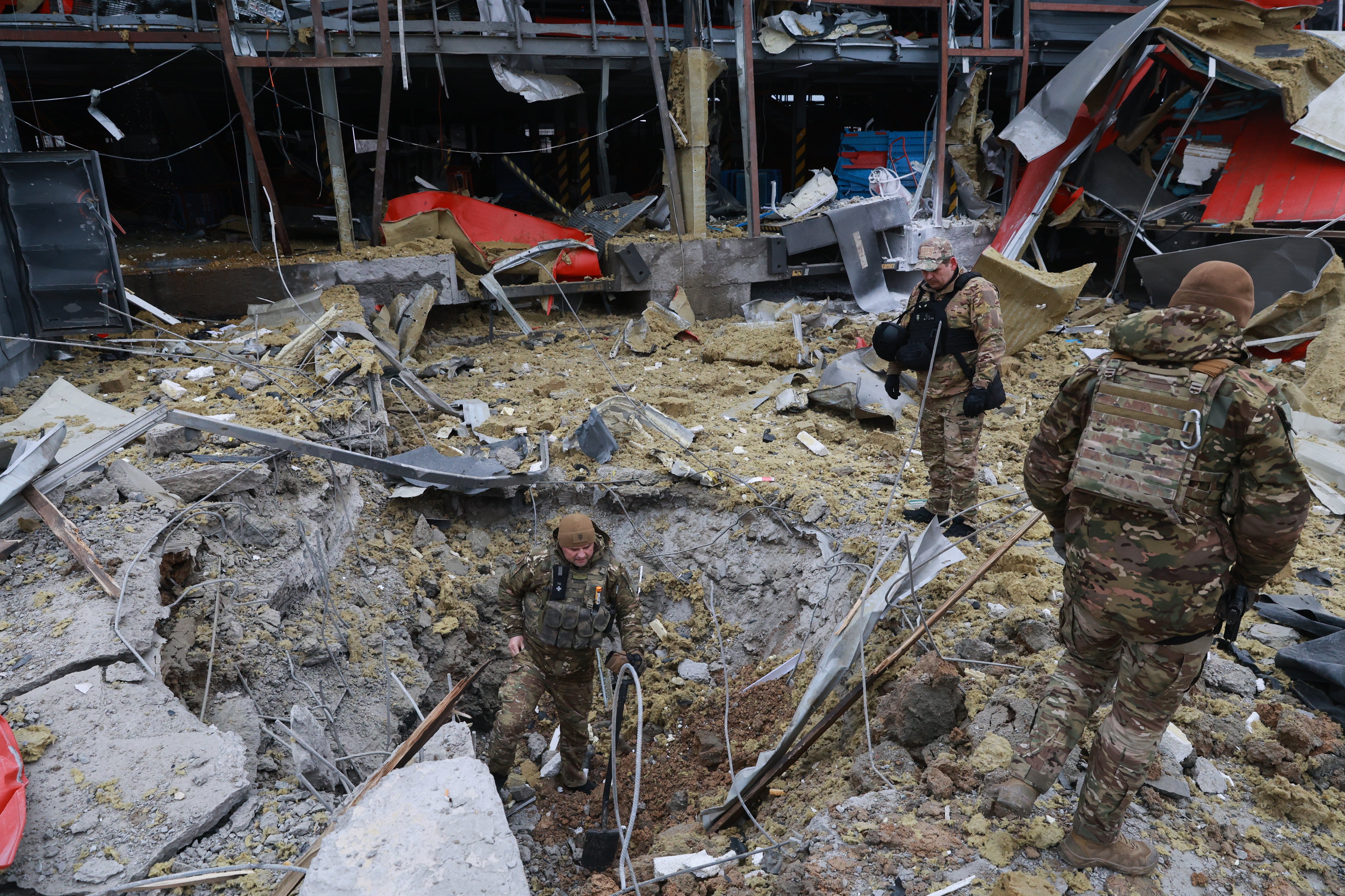 Sappers examine the site of a Russian missile strike which hit a post office storehouse in Zaporizhzhia on Tuesday