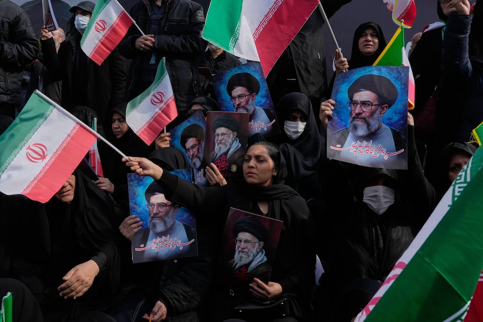 People wave Iranian flags as they hold posters of the late Supreme Leader Ayatollah Ali...