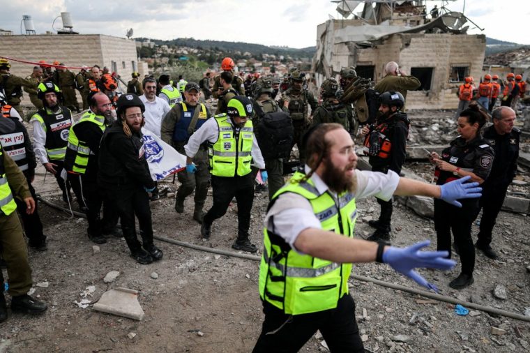 Emergency personnel carry a body at the site of an Iranian strike, after Iran launched missile barrages following attacks by the U.S. and Israel on Saturday, in Beit Shemesh, Israel March 1, 2026. REUTERS/Ammar Awad TPX IMAGES OF THE DAY
