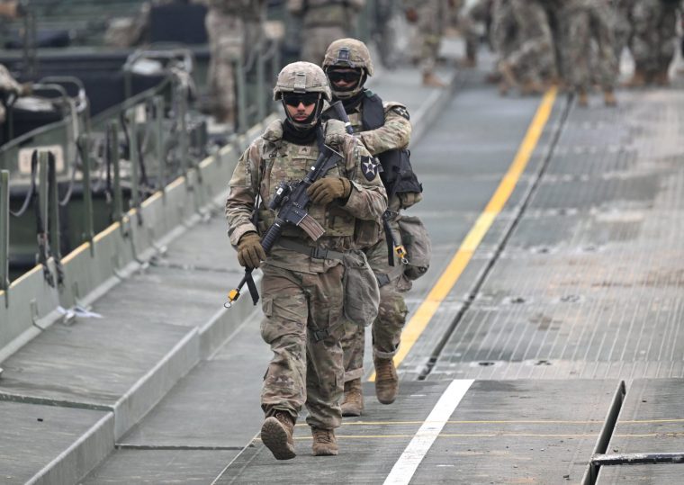 US soldiers cross a river over a floating bridge as they participate in a combined maneuver training with wet gap crossing during the 2026 South Korea-US Freedom Shield military exercise in Yeoncheon on March 14, 2026. (Photo by Jung Yeon-je / AFP via Getty Images)