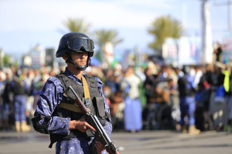 A security personnel stands guard as Houthi supporters gather during a rally in solidarity with Iran and Lebanon, amid the US-Israeli war with Iran, in the Yemeni capital Sanaa on March 27, 2026. Abdul Malik al-Houthi, leader of Yemen's Iran-backed Houthi movement, warned on March 26 of a "military response" should the Middle East war require it. The Houthis, a key part of Iran's so-called "axis of resistance", have so far refrained from joining the war sparked by US-Israeli strikes on Iran, which has engulfed much of the region. (Photo by Mohammed HUWAIS / AFP via Getty Images)