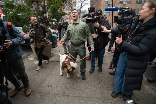 Jake Lang walks with a goat to a secured protest area near Gracie Mansion on Saturday. 