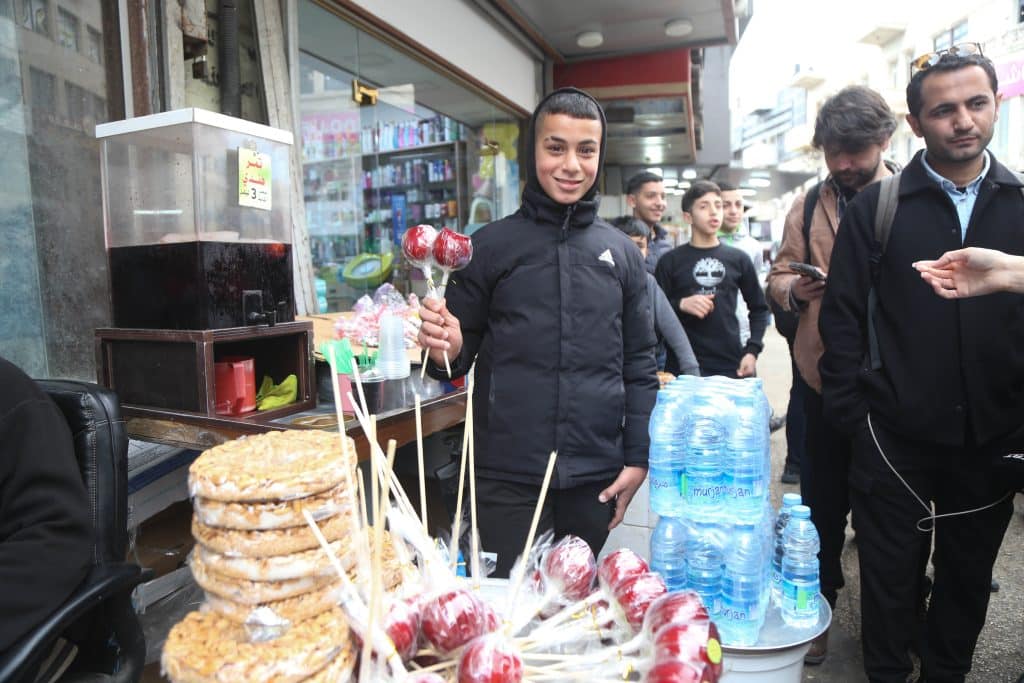 Talal Adabiq, 15, dropped out of school to sell sweets in the Old City of Nablus to support his family. (Photo: Ghassan Bannoura)