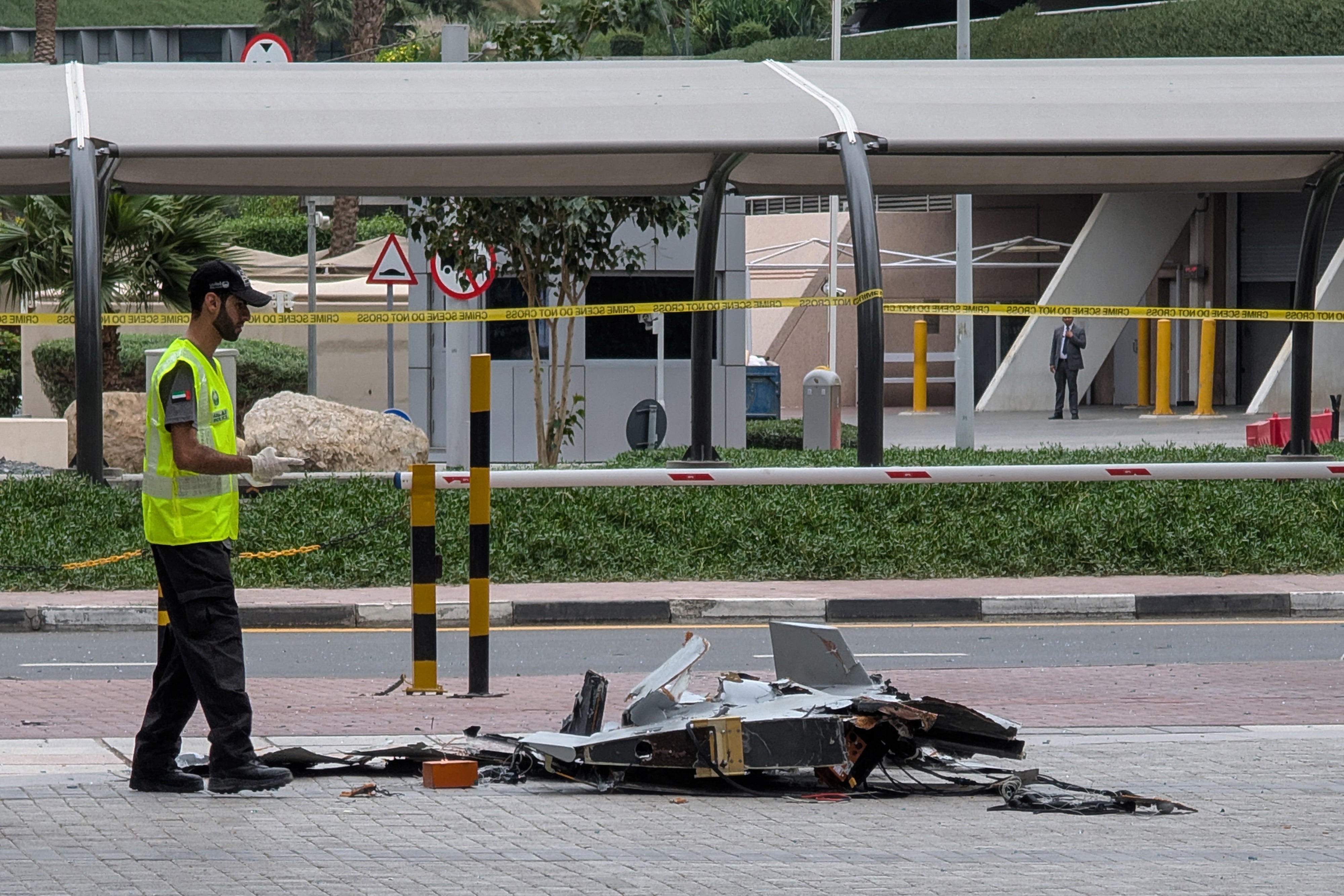 A police officer inspects the wreckage of a drone in downtown Dubai