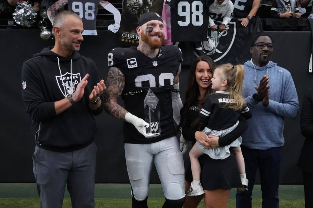 Maxx Crosby, with his wife and daughter and Raiders GM John Spytek, receives the team's Walter Payton Man of the Year award.
