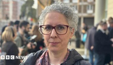 A nurse or medical practitioner wearing gloves and holding a Covid test. Behind her is a an extract of a handwritten document with words highlighted saying: "To stop NHS collapse".