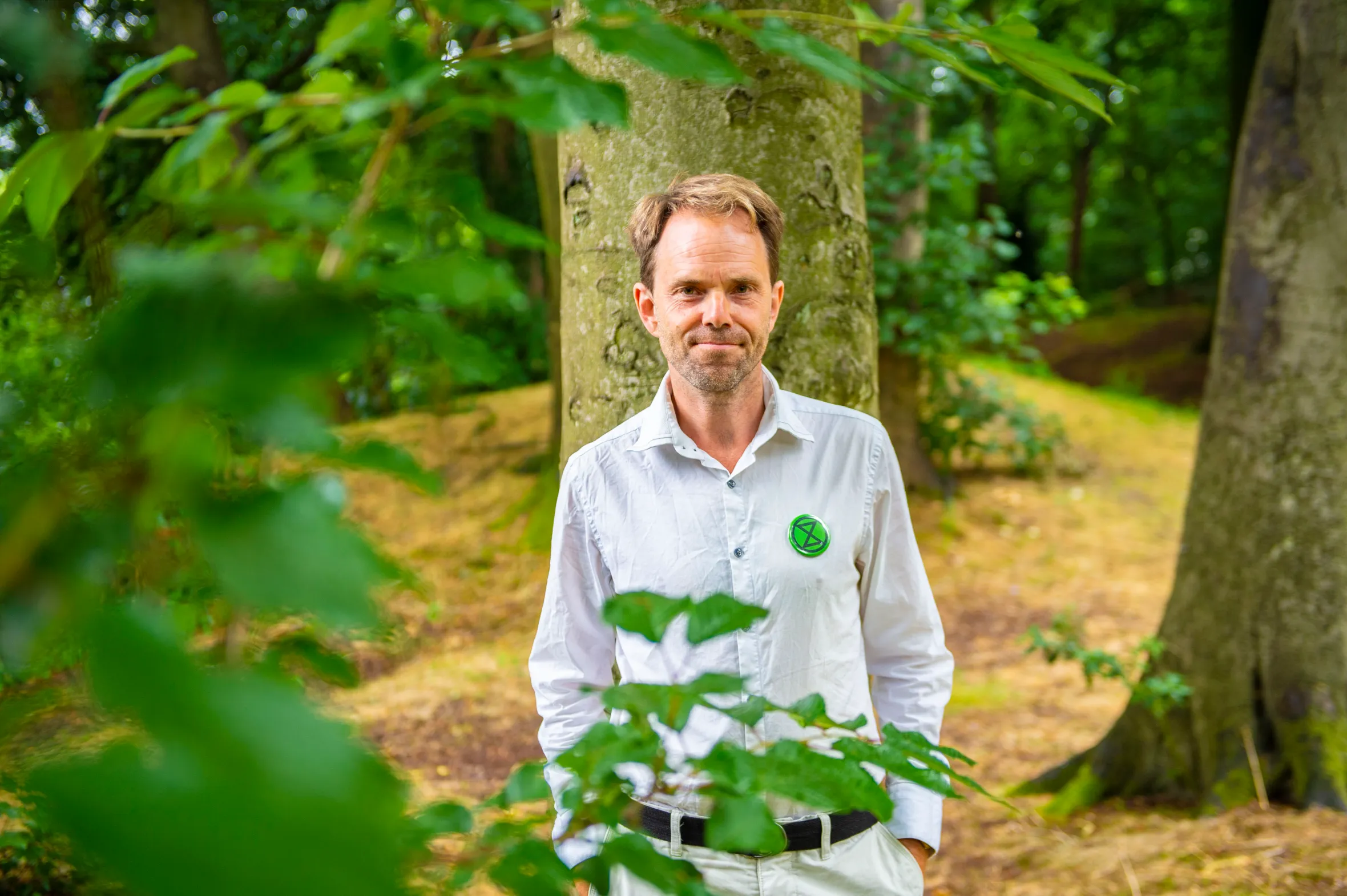 Dr. Rupert Read of Extinction Rebellion wearing a green and black Extinction Rebellion badge on his white shirt.