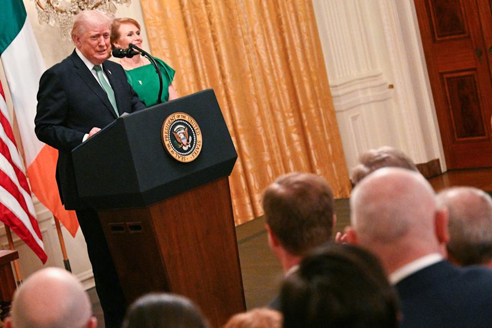 US President Donald Trump speaks Irish Prime Minster Micheal Martin's wife Mary O'Shea looks on, on the occasion of St. Patrick's Day, in the East Room of the White House in Washington, DC, on March 17, 2026. (Photo by Jim WATSON / AFP via Getty Images)