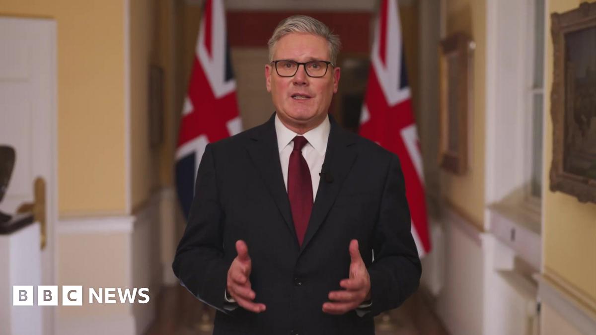 Catherine wearing burgundy carrying yellow daffodils and Welsh flags as people take pictures in the background