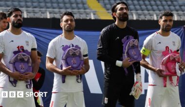 Iran's Hossein Kanaani, Shoja Khalilzadeh, Alireza Beiranvand and Mehdi Taremi hold school bags in memory of the victims of the girls school bombing in Minab, Iran