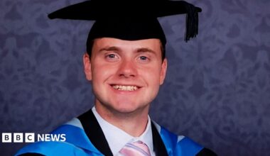 Jack O'Sullivan pictured in his blue graduation robes, wearing a black mortar board and smiling at the camera.