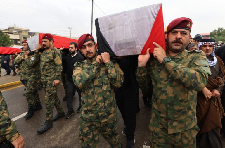 Members of Iraq's Hashed al-Shaabi, an alliance of factions now integrated into the regular army, carry the coffin of the Hashd al-Shaabi operations commander for Al-Anbar, Saad Dawai alongside others during a mass funaral in Baghdad on March 24, 2026.