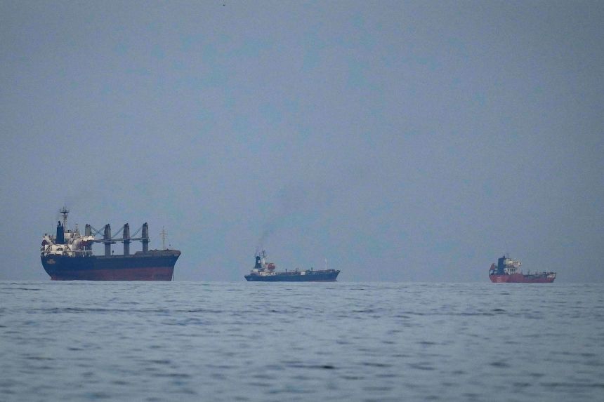 Oil tankers and ships line up in the Strait of Hormuz as seen from Khor Fakkan, United Arab Emirates on March 11.