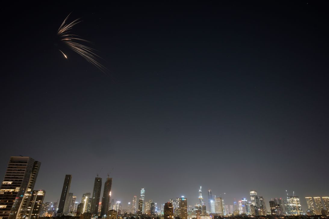 Missiles launched from Iran streak across the sky over central Israel, early Wednesday, March 18, 2026.