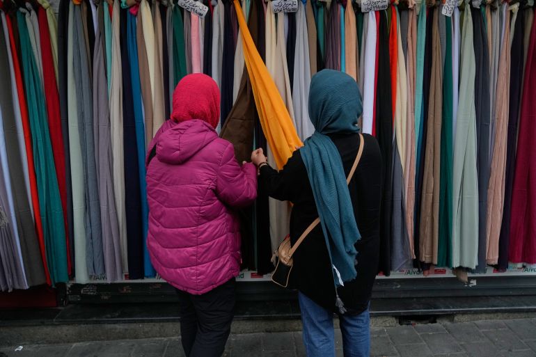 Women examine headscarves for sale in northern Tehran, Iran, Tuesday, March 24, 2026. (AP Photo/Vahid Salemi)