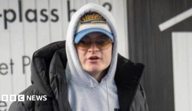 Sturla Henriksboe (R) wearing a black gown over a white shirt and patterned blue and lilac tie stands in front of a microphone as police prosecutor Andreas Kruszewski sit alongside to his right, his head shaved, sporting a black beard and wearing glasses