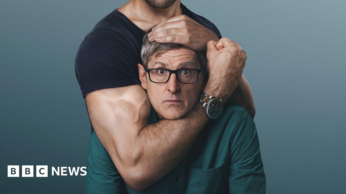 A woman with dark hair and a multiple colour jumper siting on a green sofa inside her living room.