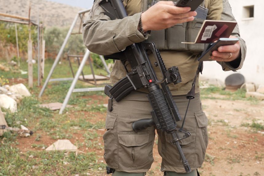 An israeli soldier's gun is seen as soldiers detain CNN crew members.