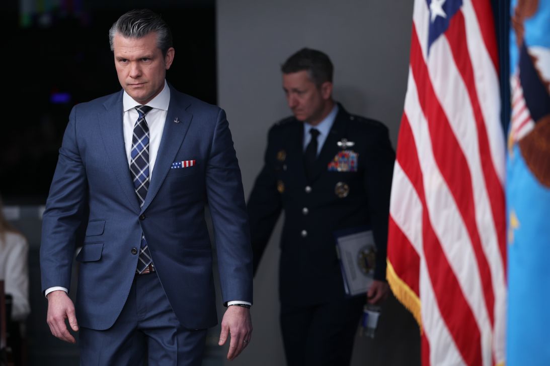 Secretary of War Pete Hegseth (L) arrives for a press briefing with Chairman of the Joint Chiefs of Staff Air Force General Dan Caine (R) at the Pentagon on Thursday in Arlington, Virginia.