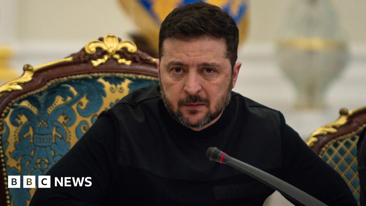 President of Ukraine Volodymyr Zelenskyy speaks at a meeting of the National Security and Defense Council on March 3, 2026 in Kyiv, Ukraine. He's leaning forward in his chair over a microphone, with a serious look on his face, and is dressed all in black