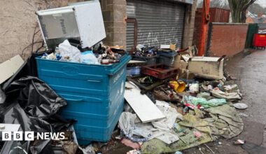 Contractors work to remove a pile of waste from Watery Lane, on the outskirts of Lichfield in Staffordshire.