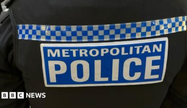 Black uniform with blue and white Sillitoe tartan and "Metropolitan Police" writing