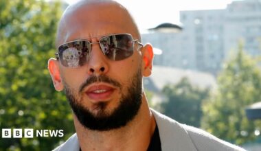 A shot of Andrew Tate from the shoulders up showing him outside wearing a pair of sunglasses.