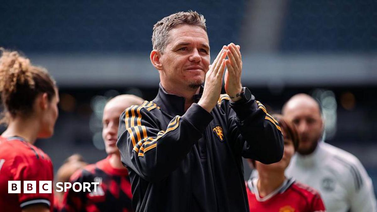 Marc Skinner, in black tracksuit top with orange stripes, applauds with players and staff in the background