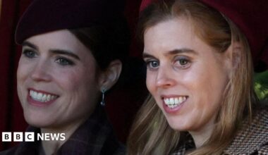 Princesses Eugenie and Beatrice, seen in close-up, smiling and looking off camera - they are both wearing coats and hats
