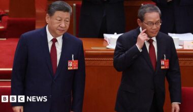 China's President Xi Jinping standing next to Premier Li Qiang as they take their seats at the opening session of the National People's Congress (NPC) at the Great Hall of the People in Beijing on 5 March