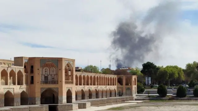 A building in Isfahan with smoke coming upwards in the distance