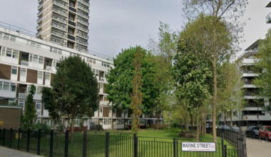A general view of  a street in Bermondsey. A road name sign is attached to a metal fence, which reads: Marine Street.