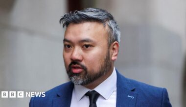 Defendant Chi Leung Wai, also known as Peter Wai, arrives at the Old Bailey, wearing a white shirt, dark tie and blue suit. He has a short salt-and-pepper beard and hair.