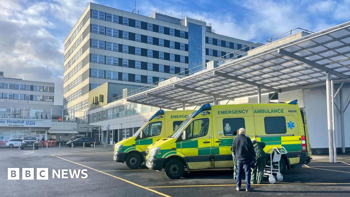 Ambulances parked outside a large white hospital building.