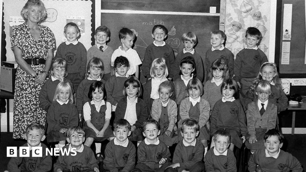 A black-and-white photo of a teacher with a class of 5 and 6-year-old pupils from Dunblane Primary School.