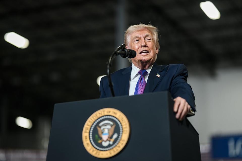 Donald Trump delivering a speech at a manufacturing plant from behind the presidential podium.