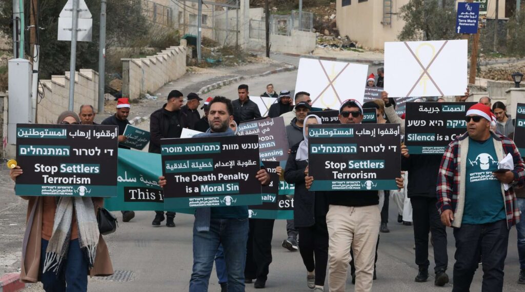 A photo of protesters walking down the street with signs.