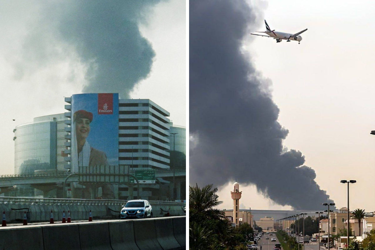 a plane flying over a building with smoke coming out of it